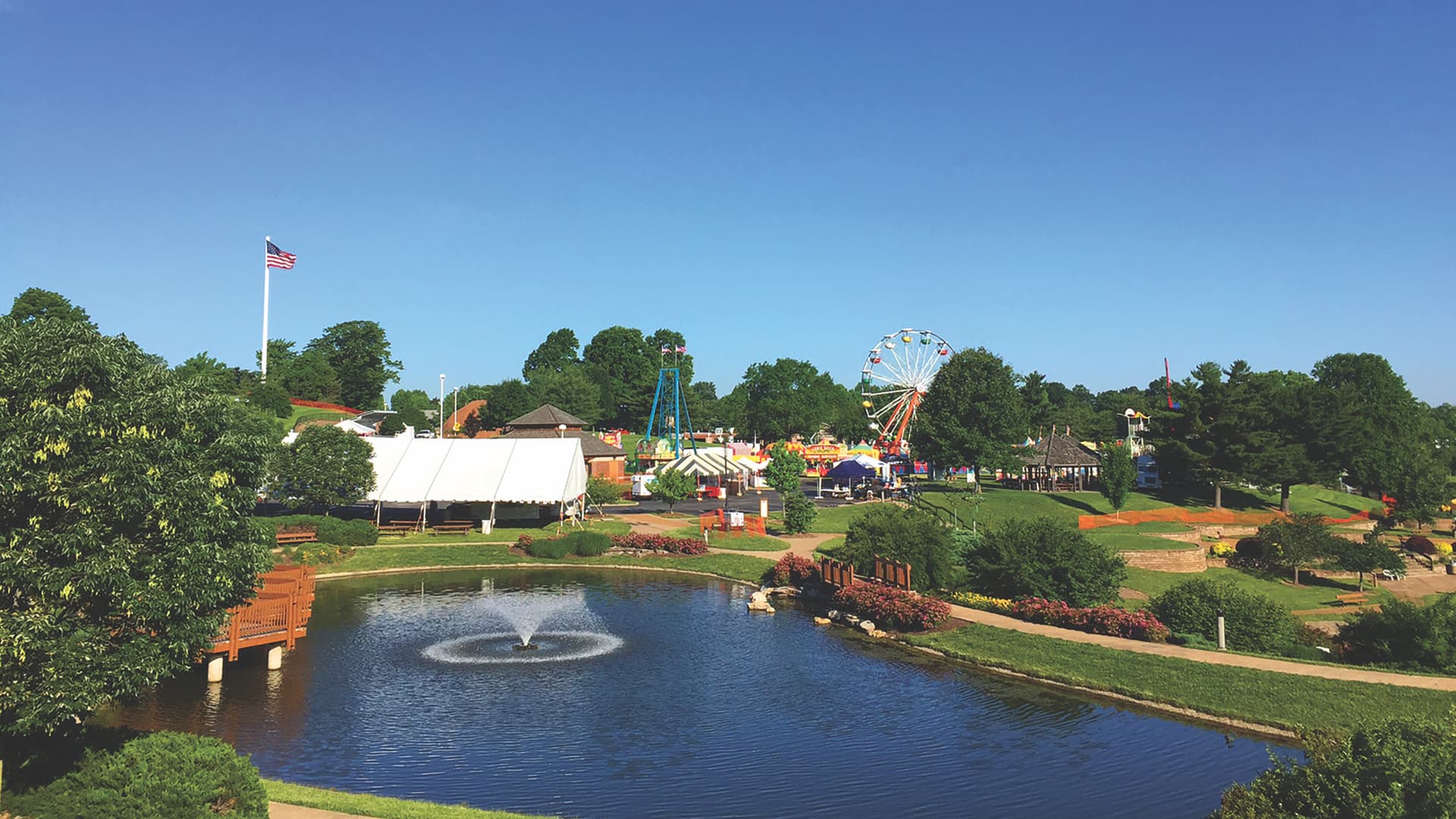 Vlasis Park panorama with pond, fountain, and bridge in Ballwin